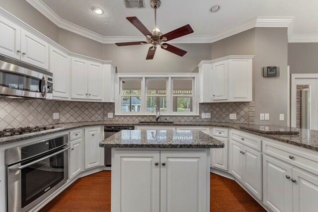 kitchen featuring white cabinetry, appliances with stainless steel finishes, sink, and kitchen peninsula