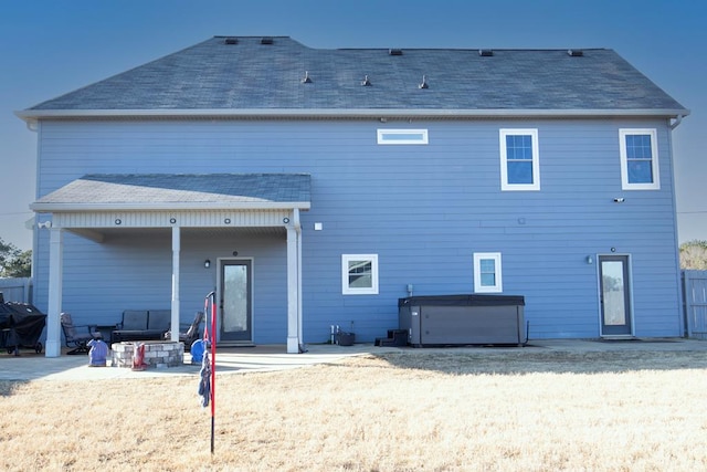 back of property featuring a hot tub and a patio