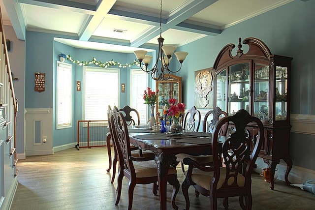 dining area with beamed ceiling, light wood-type flooring, coffered ceiling, crown molding, and an inviting chandelier