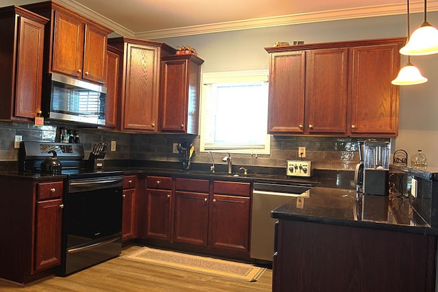 kitchen featuring sink, decorative light fixtures, light wood-type flooring, ornamental molding, and stainless steel appliances