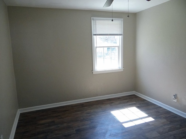 spare room with ceiling fan, dark wood finished floors, and baseboards