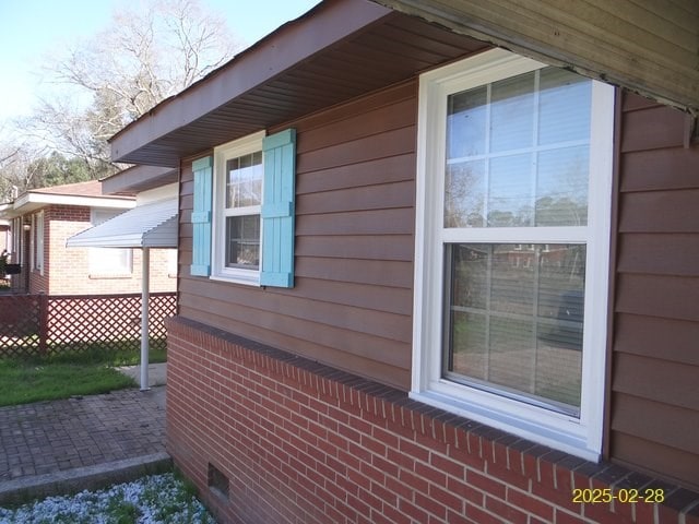 view of home's exterior with fence and brick siding