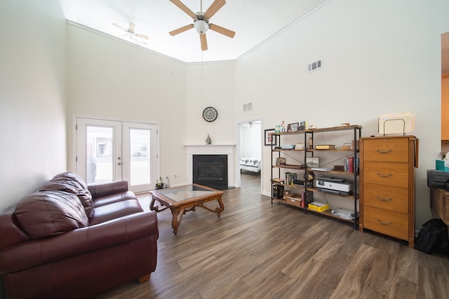 living room featuring a high ceiling, dark wood-type flooring, french doors, and ceiling fan