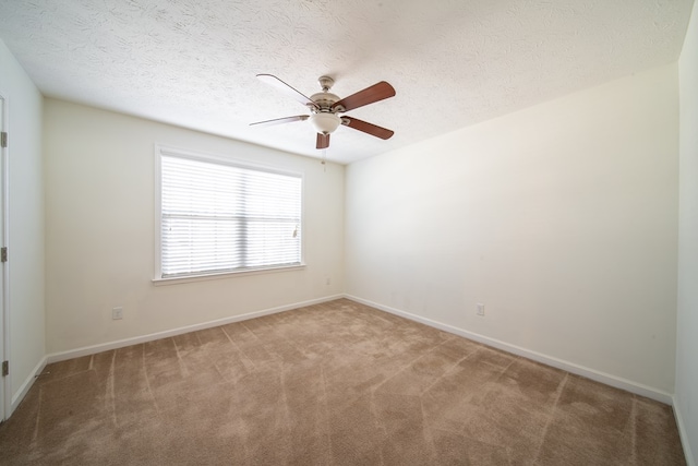 empty room featuring carpet floors, ceiling fan, and a textured ceiling