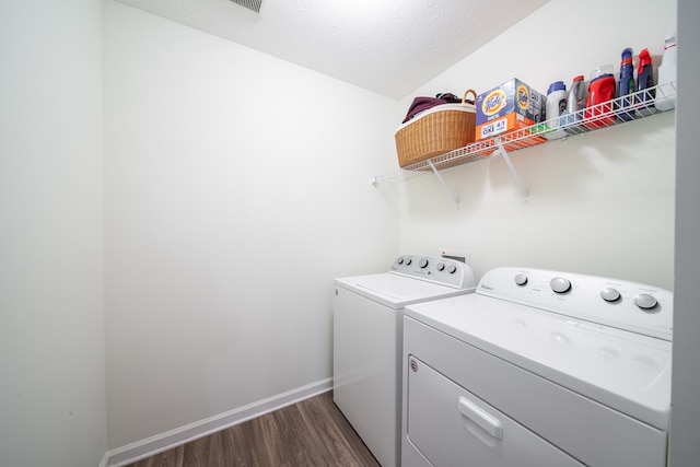 washroom with dark hardwood / wood-style flooring, independent washer and dryer, and a textured ceiling