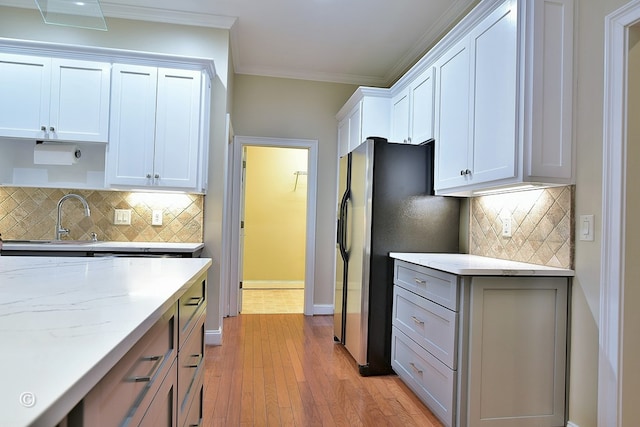 4701 Turnberry Ln Unit 12, Columbus, GA 31909 - kitchen with light wood finished floors, decorative backsplash, light stone countertops, stainless steel refrigerator with ice dispenser, and ornamental molding