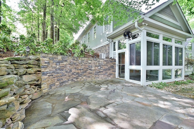 4701 Turnberry Ln Unit 12, Columbus, GA 31909 - view of home's exterior featuring stone siding, a patio area, and a sunroom