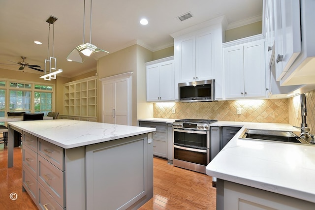 4701 Turnberry Ln Unit 12, Columbus, GA 31909 - kitchen with stainless steel appliances, a sink, a kitchen island, crown molding, and ceiling fan