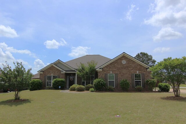 view of front facade with brick siding and a front yard
