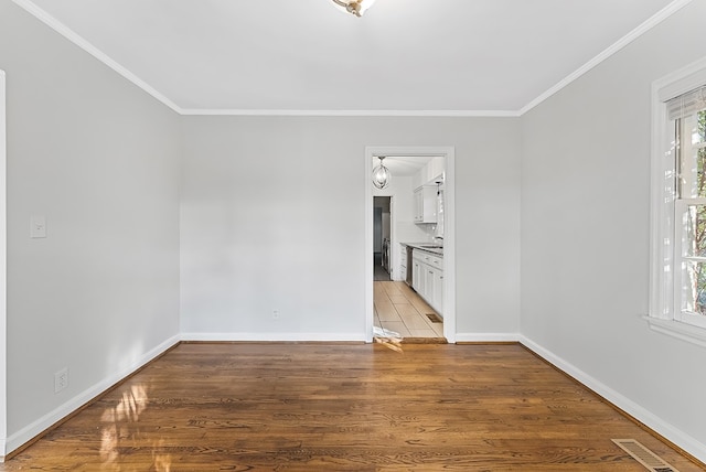 spare room with hardwood / wood-style floors and crown molding