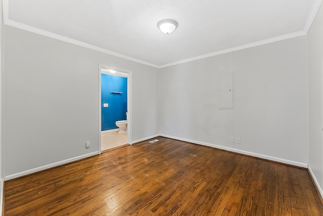 unfurnished room featuring hardwood / wood-style flooring, electric panel, and crown molding