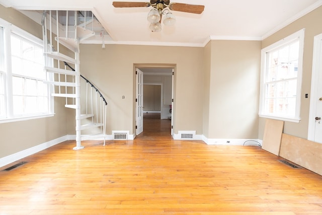 spare room with crown molding, visible vents, and light wood-style floors