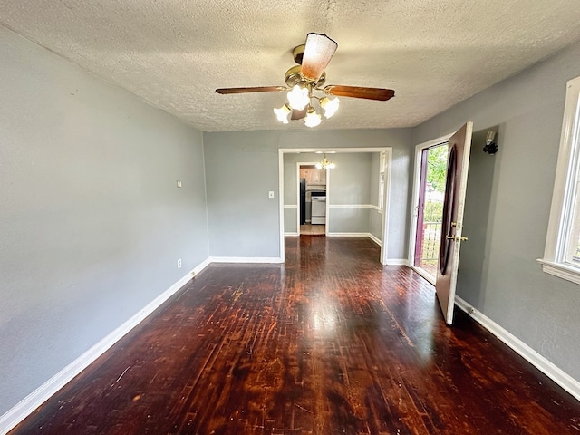 empty room with ceiling fan, dark hardwood / wood-style flooring, and a textured ceiling