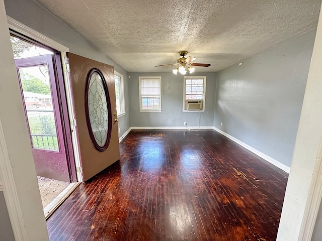 foyer featuring a textured ceiling, cooling unit, ceiling fan, and dark wood-type flooring