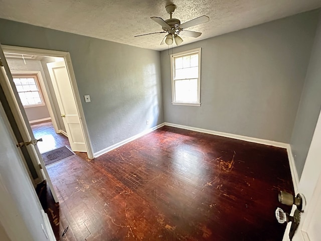 unfurnished room with a wealth of natural light, ceiling fan, a textured ceiling, and hardwood / wood-style flooring