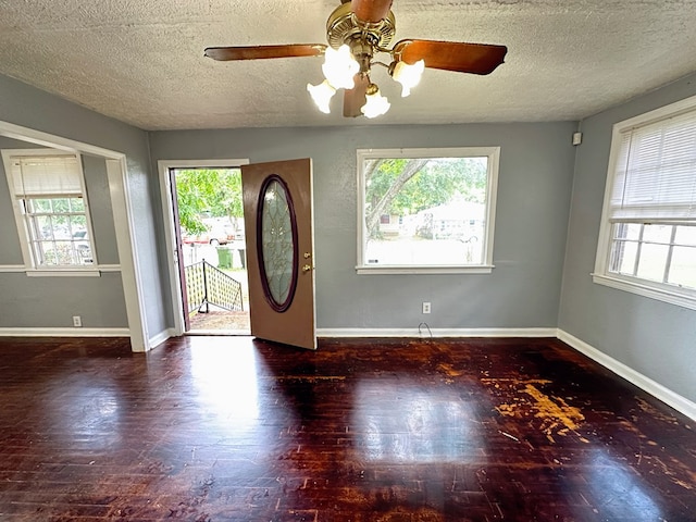 foyer featuring a textured ceiling, dark hardwood / wood-style flooring, ceiling fan, and a healthy amount of sunlight