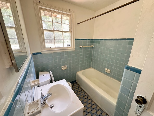 bathroom featuring tile patterned floors, shower / tub combination, tile walls, and toilet