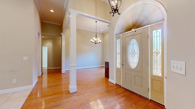 5007 Spyglass Ct, Columbus, GA 31909 - entrance foyer with crown molding, decorative columns, a notable chandelier, and light wood-style floors