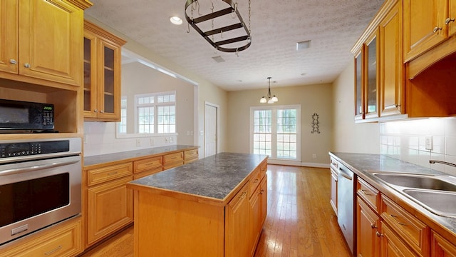 5007 Spyglass Ct, Columbus, GA 31909 - kitchen with a notable chandelier, a center island, decorative backsplash, stainless steel appliances, and a sink