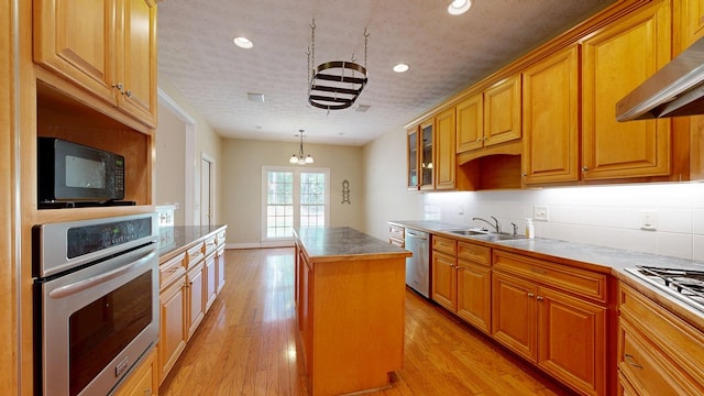 5007 Spyglass Ct, Columbus, GA 31909 - kitchen featuring a center island, exhaust hood, a sink, appliances with stainless steel finishes, and light wood-style floors