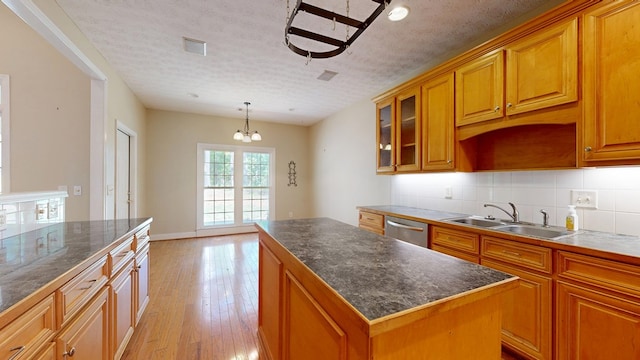 5007 Spyglass Ct, Columbus, GA 31909 - kitchen with stainless steel dishwasher, light wood-type flooring, a center island, a sink, and decorative backsplash
