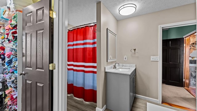 bathroom featuring hardwood / wood-style flooring, vanity, a textured ceiling, and a shower with curtain