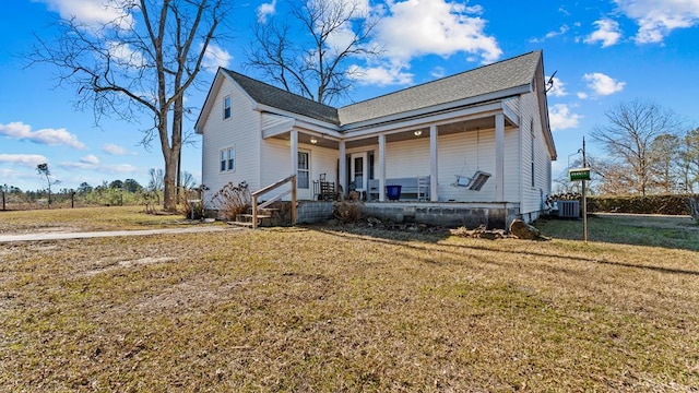 bungalow-style home featuring a porch, a front yard, and central air condition unit