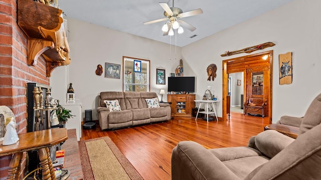 living room with hardwood / wood-style flooring, a fireplace, and ceiling fan