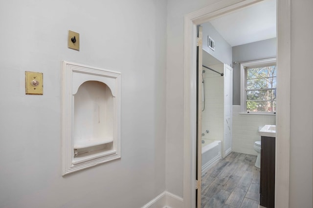 1712 Marilon Dr, Columbus, GA 31906 - bathroom featuring toilet, bathtub / shower combination, tile walls, wood finished floors, and vanity