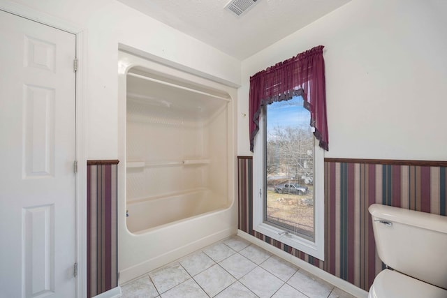 full bathroom featuring a textured ceiling, toilet, visible vents, tub / shower combination, and tile patterned floors