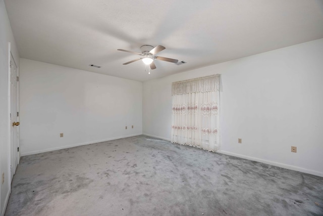 carpeted spare room featuring baseboards, visible vents, and a ceiling fan