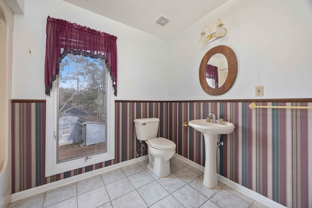 bathroom with visible vents, wainscoting, tile patterned flooring, and toilet