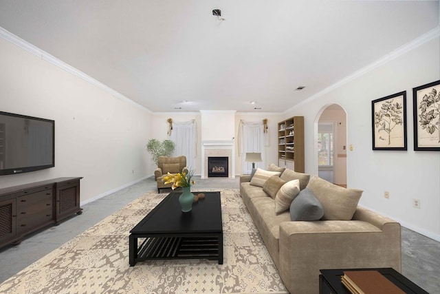 living area with arched walkways, ornamental molding, a fireplace, and baseboards