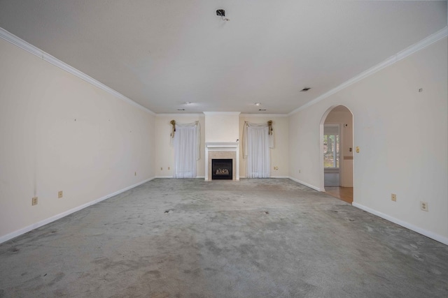 unfurnished living room featuring carpet, a fireplace, arched walkways, and crown molding