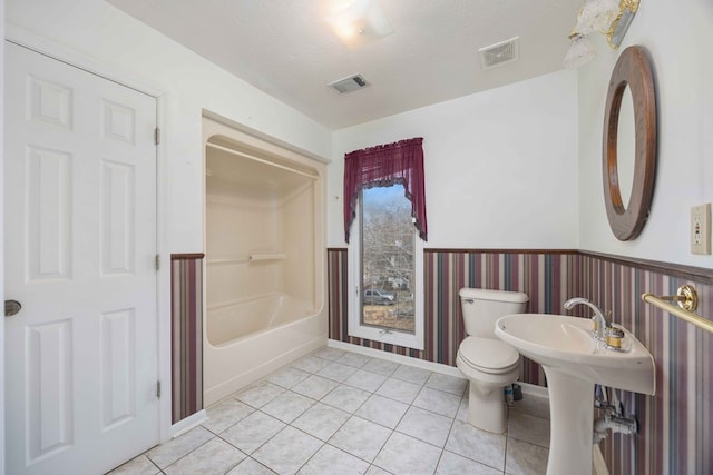 full bathroom featuring toilet, a wainscoted wall, visible vents, and tile patterned floors