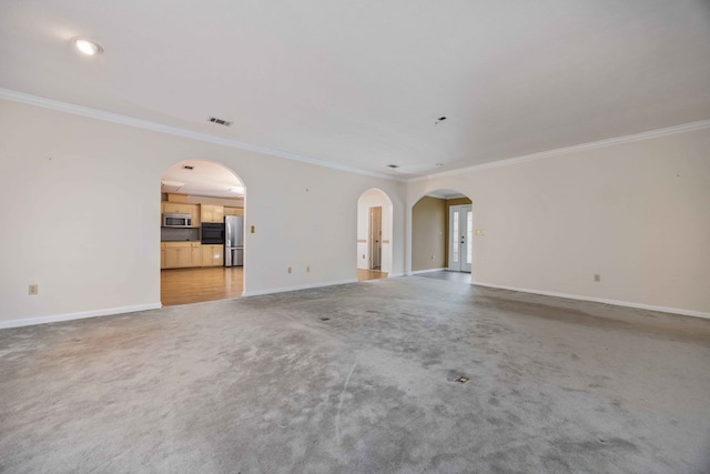 unfurnished living room featuring baseboards, visible vents, arched walkways, light colored carpet, and crown molding