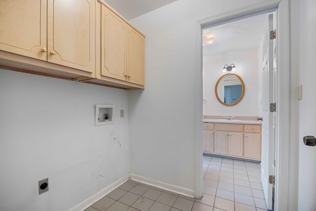 laundry area with light tile patterned floors, hookup for a washing machine, cabinet space, hookup for an electric dryer, and a sink