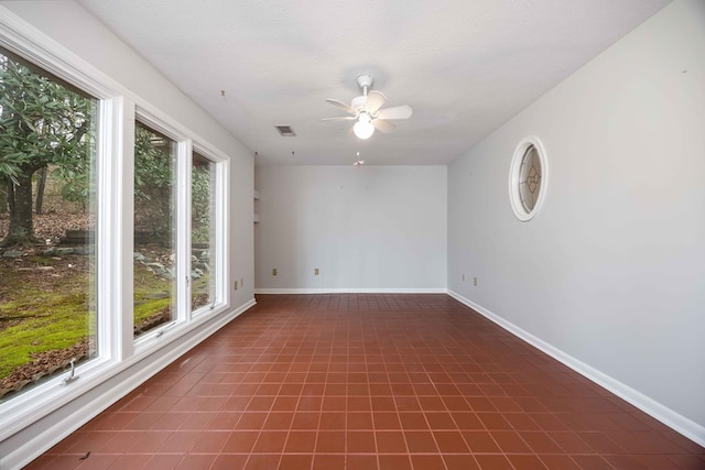 spare room featuring visible vents, ceiling fan, a textured ceiling, and baseboards