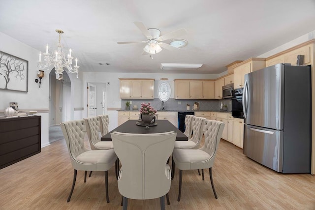 dining area with a chandelier, light wood finished floors, and visible vents