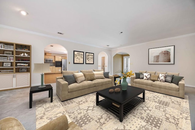 living room featuring arched walkways, visible vents, ornamental molding, carpet flooring, and baseboards