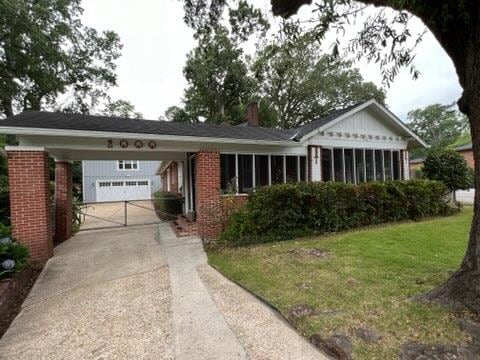 single story home featuring a front lawn and a carport