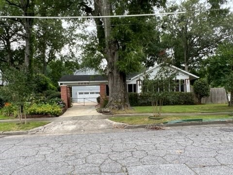 single story home with a garage and a front yard