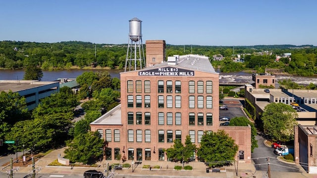 drone / aerial view featuring a wooded view and a water view