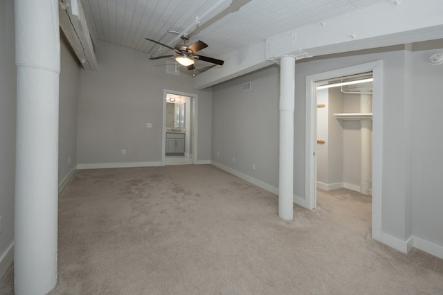 unfurnished bedroom featuring ensuite bathroom, baseboards, light colored carpet, a spacious closet, and ornate columns