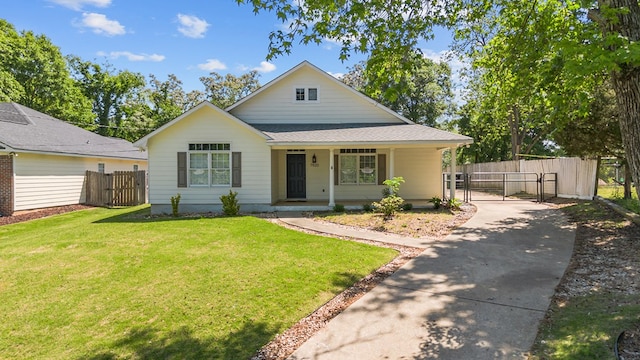 bungalow with a front lawn, a gate, driveway, a porch, and fence