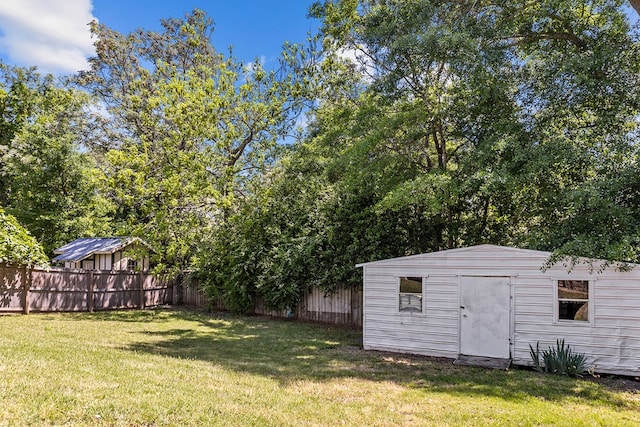 view of yard featuring a fenced backyard, an outbuilding, and a storage shed