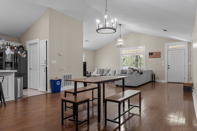 dining space with wood-type flooring, baseboards, a chandelier, and visible vents