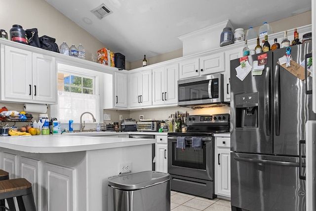 kitchen featuring electric stove, black fridge with ice dispenser, stainless steel microwave, a peninsula, and visible vents