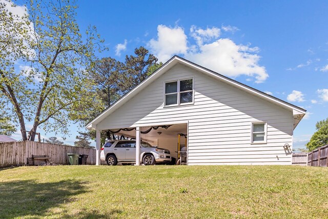 view of property exterior with a lawn and fence