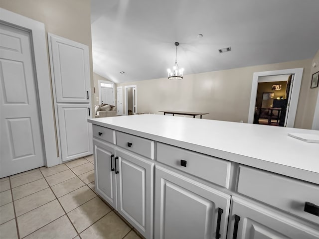 kitchen with vaulted ceiling, light tile patterned floors, light countertops, white cabinetry, and visible vents